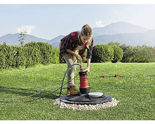 Žena připojuje ponorné čerpadlo na zahradě