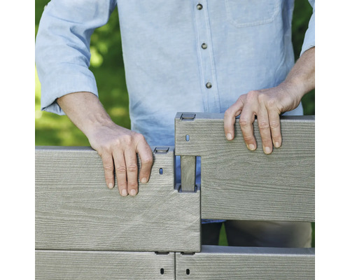 Osoba montuje kompozitní plot.