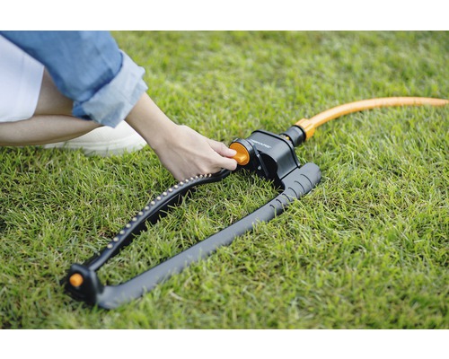 Zahradní postřikovač na trávníku s nastavitelnou tryskou