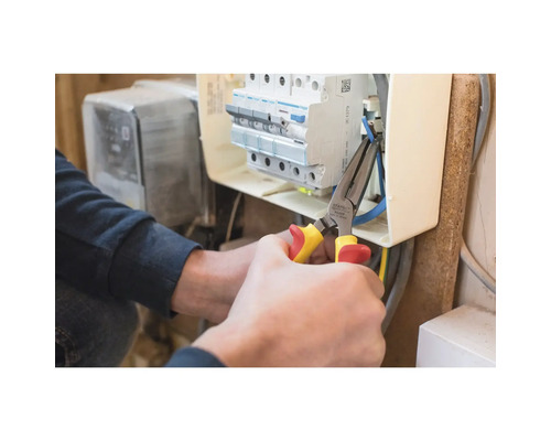 Elektrikář pracuje s kombinovanými kleštěmi na rozvodné skříni