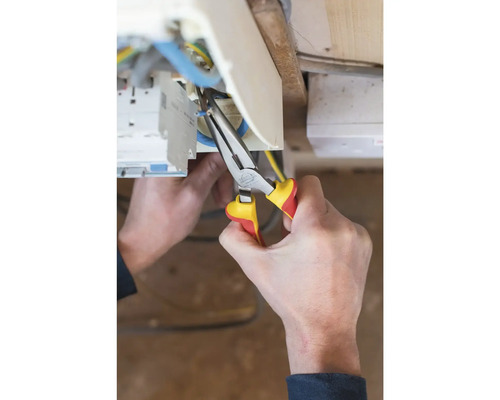 Elektrikář pracuje s kombinovanými kleštěmi na elektrickém vedení