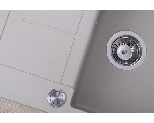 Detailní pohled na kuchyňský dřez s odkapávací plochou a nerezovou odtokovou soupravou