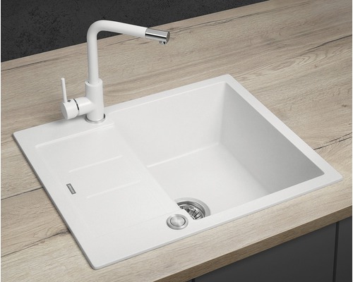 Bílý kuchyňský dřez s odkapávací plochou a odpovídající baterií na pracovní desce
