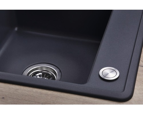 Detailní pohled na kuchyňský dřez s odtokem a ovládacím knoflíkem