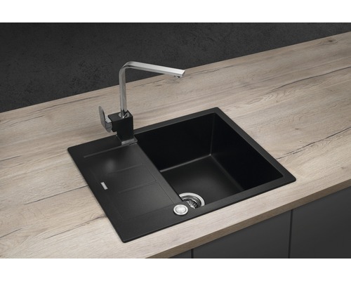 Černý kuchyňský dřez s odkapávací plochou a vodovodní baterií na pracovní desce