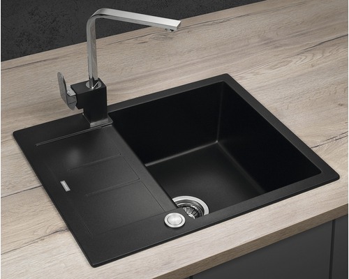 Černý kuchyňský dřez s odkapávací plochou a vodovodní baterií na pracovní desce