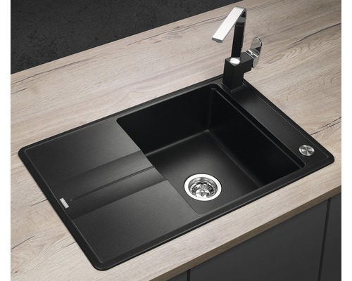 Černý kuchyňský dřez s odkapávací plochou a baterií na pracovní desce