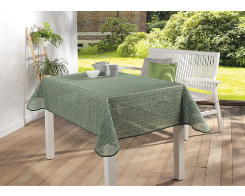 Stůl se zeleným vzorovaným ubrusem na zahradě