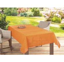 Stůl na zahradě s oranžovým ubrusem, nádobím a židlemi