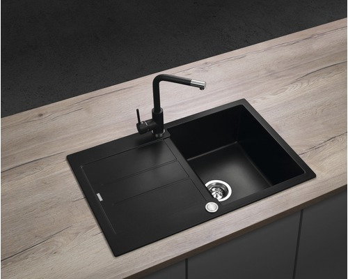 Černý kuchyňský dřez s odkapávací plochou a vodovodní baterií na pracovní desce