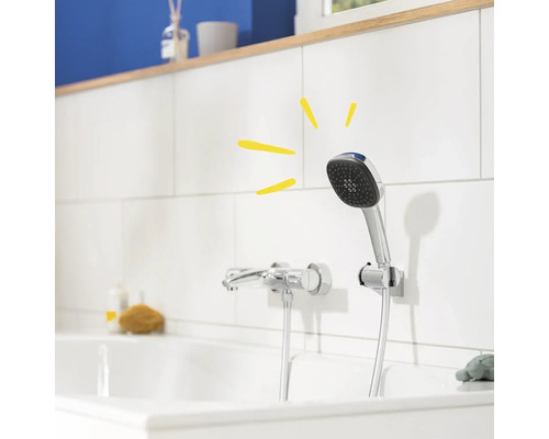 Ruční sprcha na okraji vany s armaturou a obklady