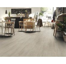 Světlá podlahová krytina ve světlé místnosti se stoly a židlemi.