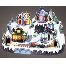 Osvětlená vánoční vesnička se domy, stromy, figurkami a vláčkem