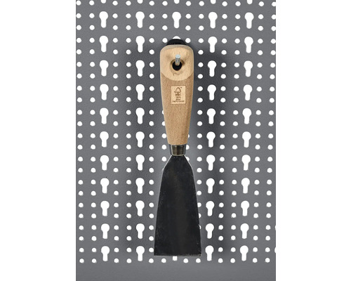 Špachtle s dřevěnou rukojetí na děrované stěně