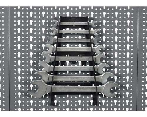 Sada očkoplochých klíčů, uspořádaných v držáku, připevněných na stěně s nářadím.