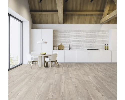 Světlý, prostorný kuchyňský kout s dřevěným trámovým stropem, jídelním stolem a kuchyňskou linkou