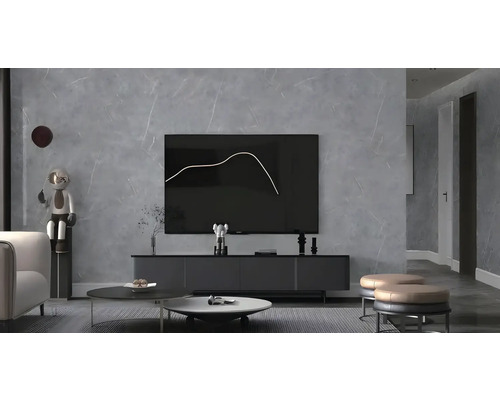 Samolepicí PVC panel Beton obklad na stěnu šedý 120 x 180 cm Moderní obývací pokoj s televizí, konferenčním stolkem a dekorativními předměty.