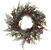 Dekorativní věnec se zelenými větvemi a červenými bobulemi jako sezónní dekorace