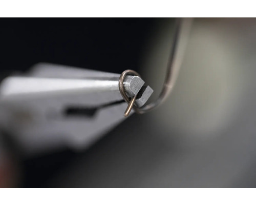 Kleště ohýbají drát.