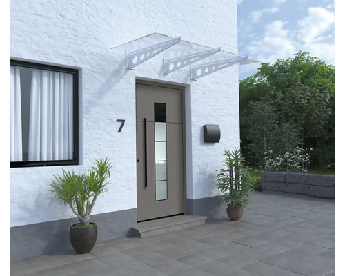 Vchodové dveře se stříškou, poštovní schránkou a rostlinami před bílou fasádou