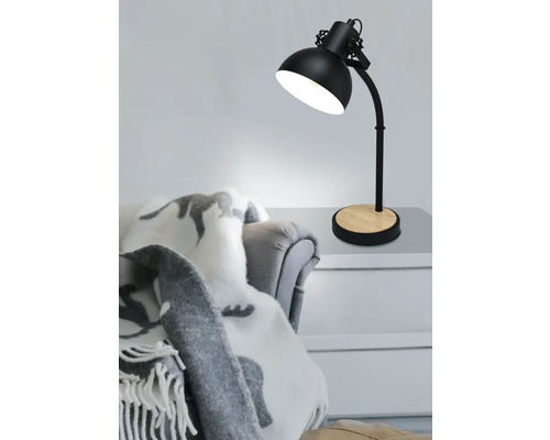 Stolní lampa s dřevěnou základnou na stole vedle křesla