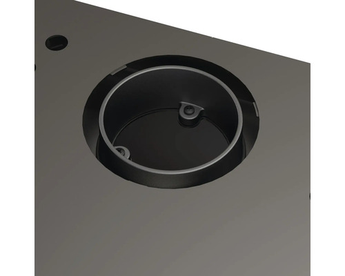 Detailní záběr kruhové kovové vložky ve stolní desce