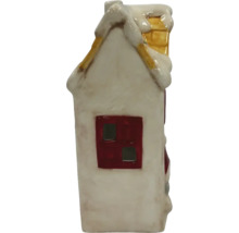 Dekorativní keramický dům se sněhem na střeše a komínem.