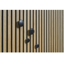 Dřevěný panel s černými kulatými háčky