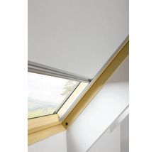 Střešní okno s roletou ve světlé místnosti