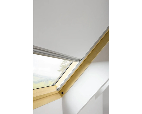 Střešní okno s roletou ve světlé místnosti