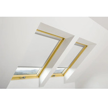 Dvě střešní okna se žaluziemi ve světlé místnosti.