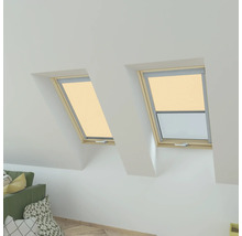 Dvě střešní okna s roletami v světlém podkrovním pokoji