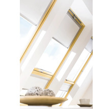 Střešní okna se žaluziemi ve světlém podkrovním pokoji