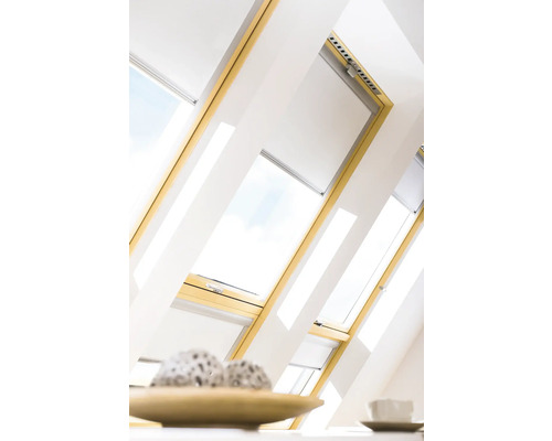 Střešní okna se žaluziemi ve světlém podkrovním pokoji