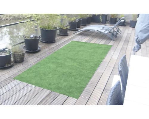 Zelený umělý trávník na dřevěné terase s květináči a lehátkem.