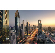 Panoramatický snímek panoramatu Dubaje s osvětlenými mrakodrapy a silničním provozem za soumraku.