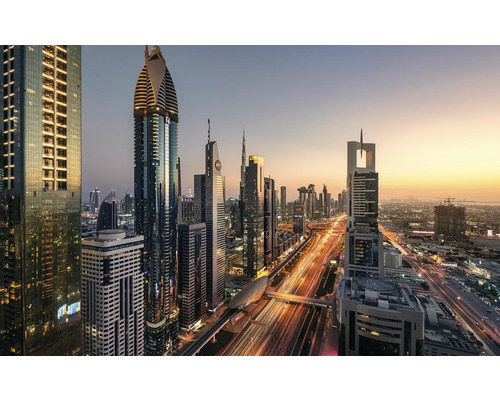 Panoramatický snímek panoramatu Dubaje s osvětlenými mrakodrapy a silničním provozem za soumraku.