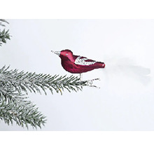 Dekorativní ptáček jako vánoční ozdoba na zasněžené větvi jedle.