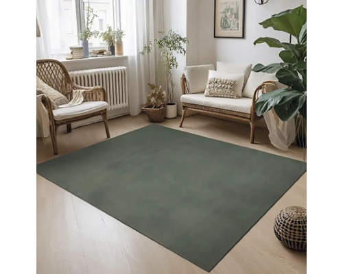 Obývací pokoj s moderním kobercem, ratanovým nábytkem a pokojovými rostlinami pro útulnou atmosféru.