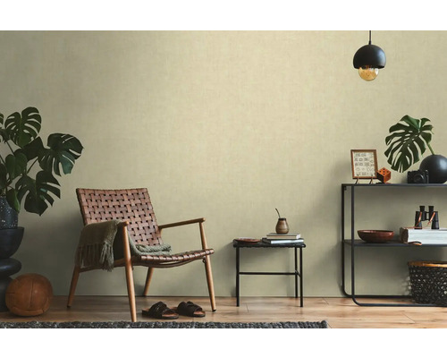 Obývací pokoj s ratanovým křeslem, odkládacím stolkem a regálem s dekoracemi pro útulnou atmosféru.