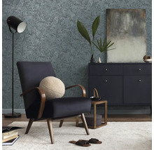 Obývací pokoj s křeslem, komodou, stojací lampou a vzorovanou tapetou