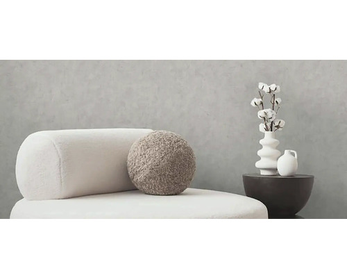 Dekorativní obytné prostředí se sedacím nábytkem, polštáři a vázami na malém stole