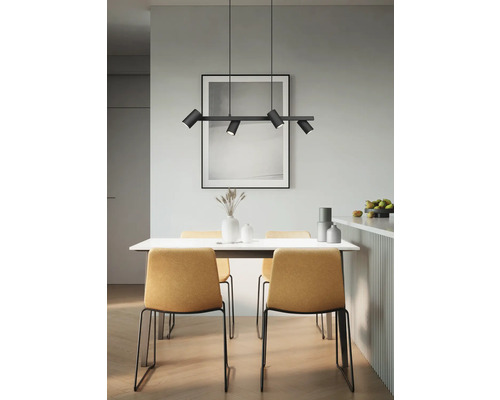 Jídelna s jídelním stolem, židlemi a černým závěsným svítidlem s několika reflektory