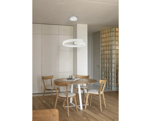 Jídelní stůl se židlemi pod moderním kruhovým závěsným svítidlem v jídelně