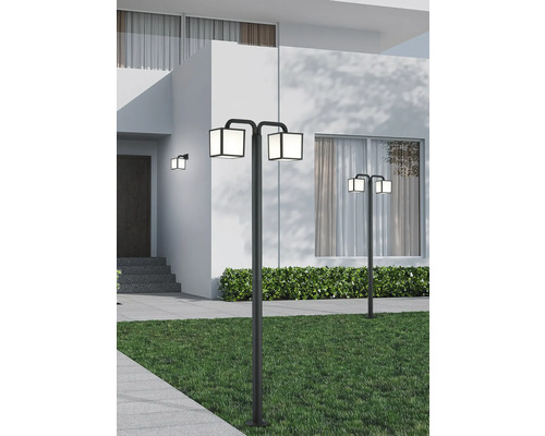 Dvě čtvercové venkovní lampy osvětlují zahradní cestu.