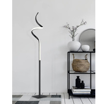 Zakřivená stojací lampa vedle regálu s dekorací