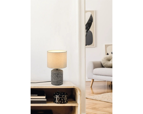 Dekorativní stolní lampa na nočním stolku v obývacím pokoji.