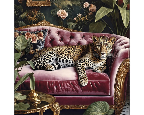 Leopard leží na červené pohovce před květinovou výzdobou.