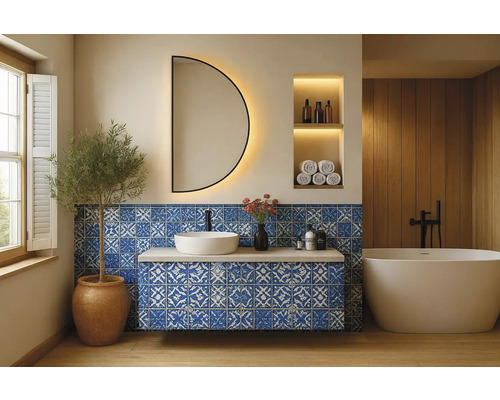 Koupelna s umyvadlem, zrcadlem, vanou a modrými dlaždicemi se vzorem