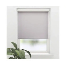 Pohled na okno s šedou roletou.